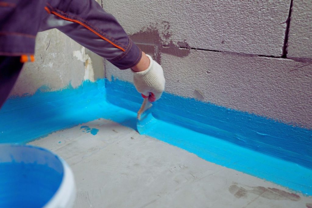 Certified waterproofer applying liquid membrane to shower floor and wall in a Sydney home, compliant with AS 3740 standards